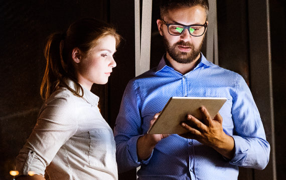 two coworkers looking at a tablet